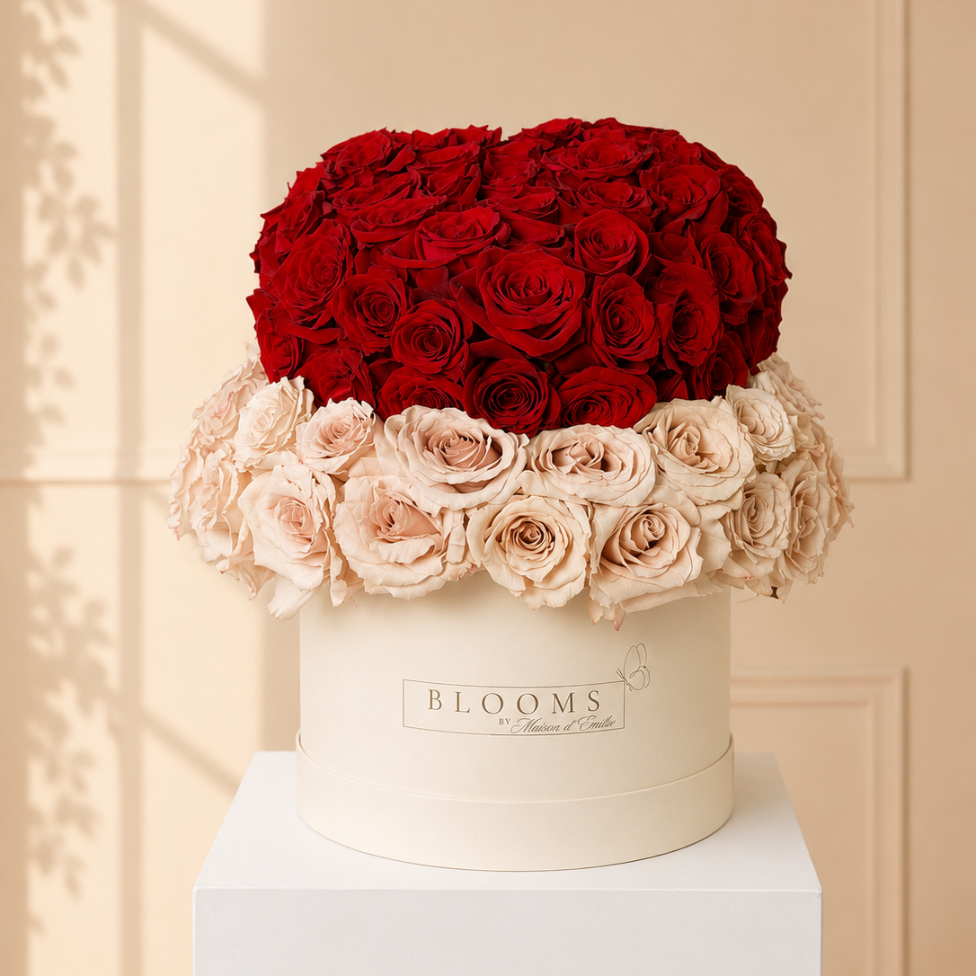 Heart-shaped arrangement of red and beige roses in a white box with